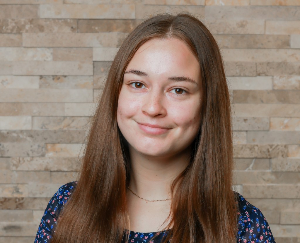 Taylor smiling at the camera in a professional headshot. 